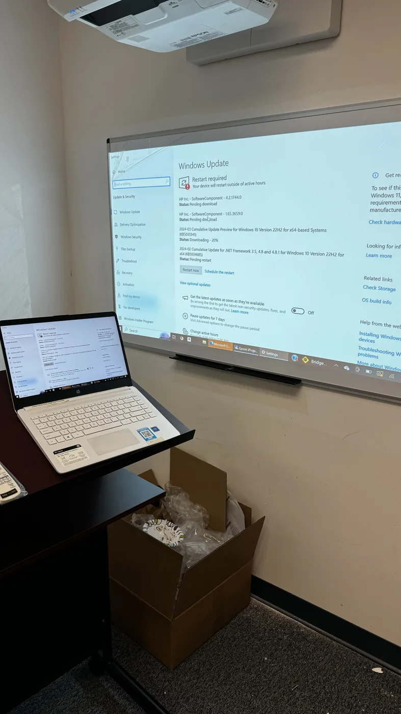 HP laptop running Windows Update on a projector screen